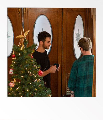 Man standing near Christmas tree whilst filming Red Letter Days Advert